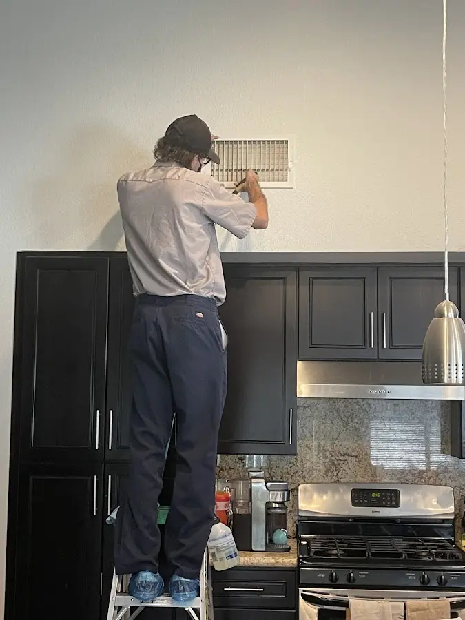 Technician inspecting an air vent during HVAC service in Bar Harbor